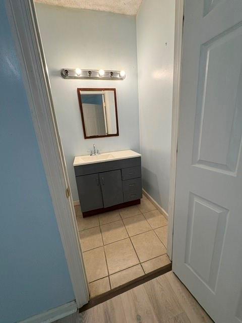 bathroom featuring vanity, wood finished floors, and baseboards
