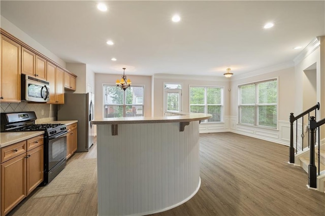 3382 Galleon Dr, Alpharetta, GA 30004 - kitchen with appliances with stainless steel finishes, a breakfast bar area, light wood-style flooring, ornamental molding, and a center island