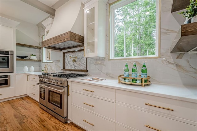 1273 Grayson Pkwy, Grayson, GA 30017 - kitchen featuring appliances with stainless steel finishes, custom exhaust hood, open shelves, white cabinets, and light countertops