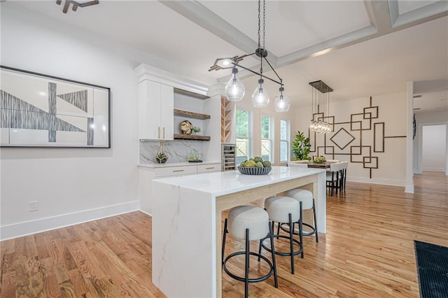 1273 Grayson Pkwy, Grayson, GA 30017 - kitchen featuring open shelves, white cabinets, light wood-style floors, light countertops, and beamed ceiling