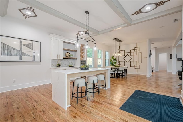 1273 Grayson Pkwy, Grayson, GA 30017 - kitchen featuring open shelves, white cabinetry, light wood finished floors, a kitchen island, and light countertops