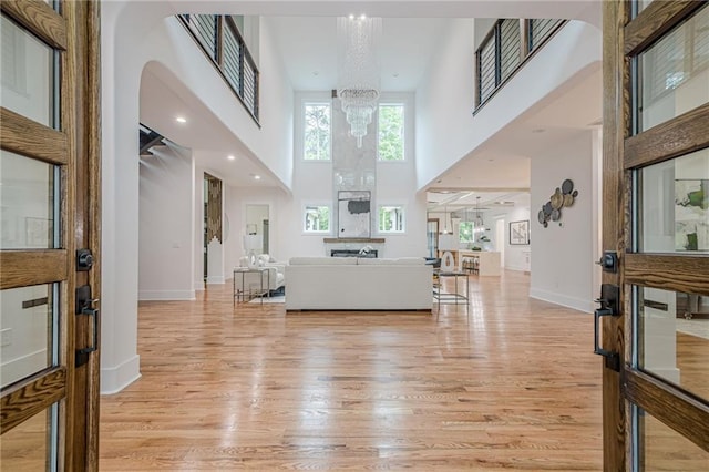 1273 Grayson Pkwy, Grayson, GA 30017 - foyer entrance featuring a high ceiling, light wood-style flooring, a chandelier, baseboards, and arched walkways