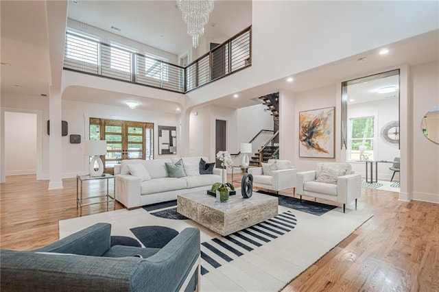 1273 Grayson Pkwy, Grayson, GA 30017 - living area with stairway, light wood-style flooring, a chandelier, baseboards, and a towering ceiling