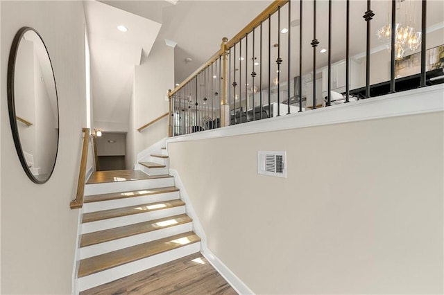 stairs featuring hardwood / wood-style floors and a high ceiling