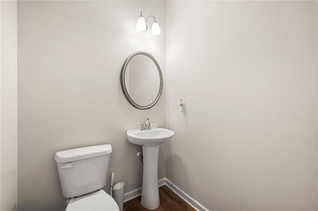 bathroom featuring wood finished floors, toilet, and baseboards