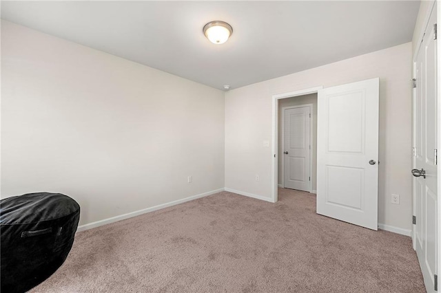 bedroom with light colored carpet and baseboards