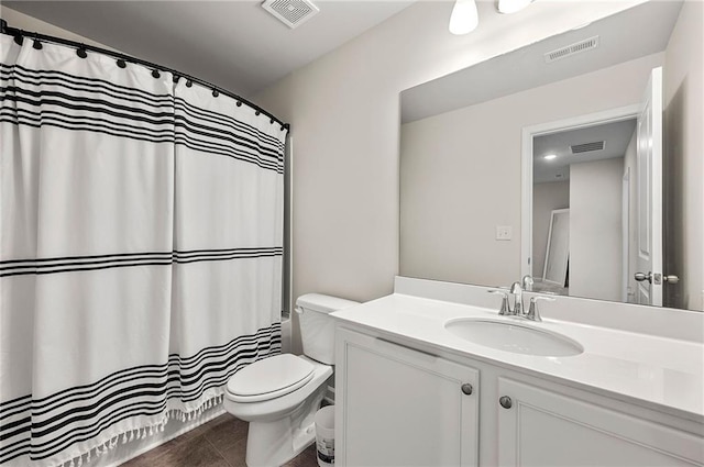 bathroom featuring toilet, visible vents, and vanity