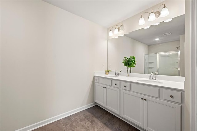 full bath with visible vents, a sink, baseboards, and an enclosed shower