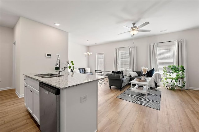 kitchen featuring light wood-type flooring, white cabinets, dishwasher, and a sink