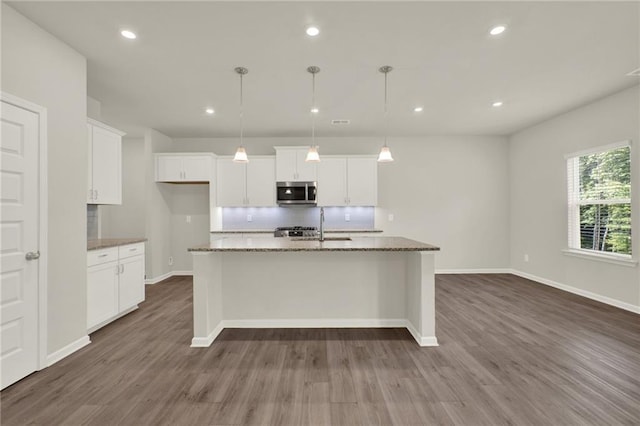 56 Preserve Pt, Jasper, GA 30143 - kitchen with stainless steel microwave, dark wood-style floors, white cabinetry, stone counters, and a center island with sink
