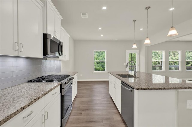 56 Preserve Pt, Jasper, GA 30143 - kitchen with stainless steel appliances, wood finished floors, backsplash, light stone counters, and white cabinetry
