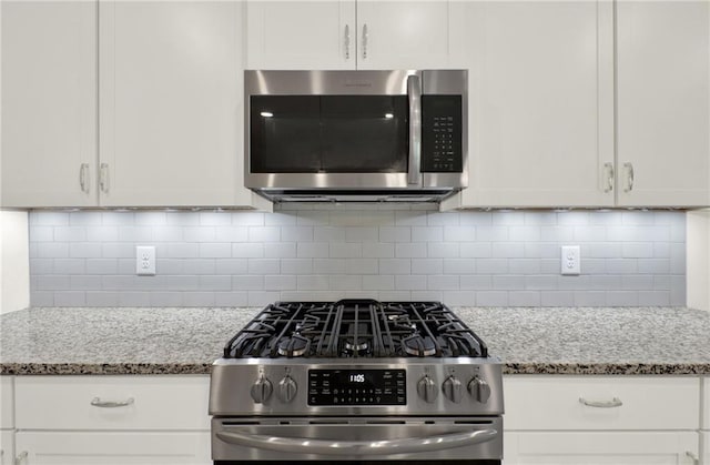 56 Preserve Pt, Jasper, GA 30143 - kitchen with appliances with stainless steel finishes, light stone counters, white cabinets, and decorative backsplash