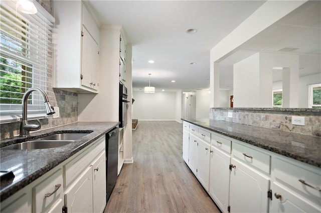 kitchen with white cabinetry, tasteful backsplash, black appliances, and a sink