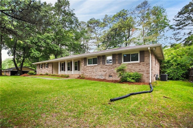 view of front of house with cooling unit, a front yard, crawl space, and brick siding
