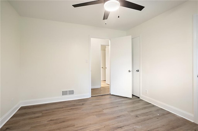 unfurnished bedroom with baseboards, visible vents, and wood finished floors