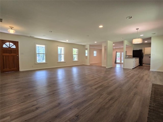 unfurnished living room featuring recessed lighting, dark wood finished floors, and baseboards