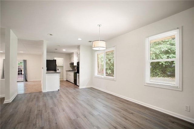 interior space featuring a wealth of natural light, wood finished floors, and baseboards