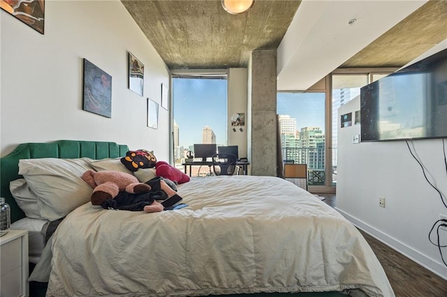 bedroom with dark wood finished floors and baseboards