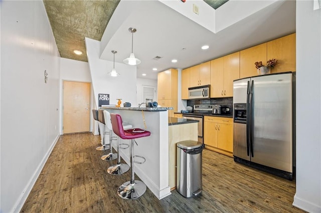 kitchen featuring dark wood finished floors, stainless steel appliances, backsplash, baseboards, and visible vents