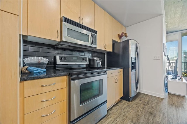 kitchen with decorative backsplash, light brown cabinetry, light wood-style floors, and appliances with stainless steel finishes