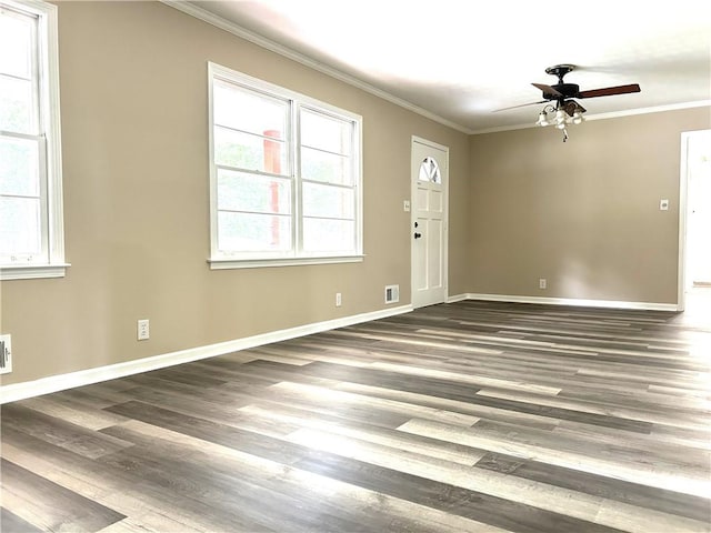 empty room with ornamental molding, dark wood-type flooring, and ceiling fan