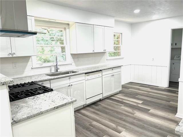 kitchen featuring plenty of natural light, tasteful backsplash, wall chimney exhaust hood, and white dishwasher