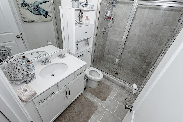 bathroom with a stall shower, vanity, and toilet