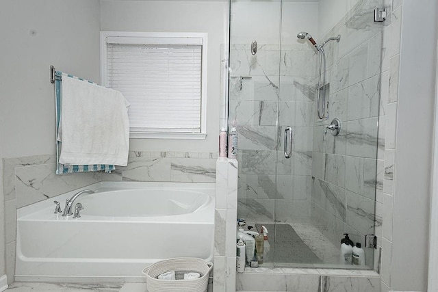 full bath with marble finish floor, a stall shower, and a bath