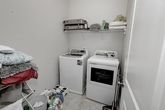 washroom with washer and dryer, laundry area, and light tile patterned floors