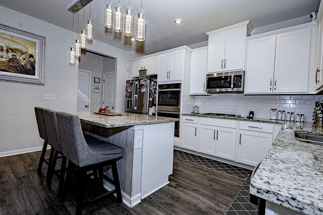 kitchen with white cabinetry, pendant lighting, and appliances with stainless steel finishes