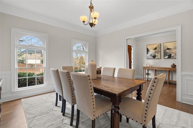 dining room with plenty of natural light, light wood-type flooring, and an inviting chandelier