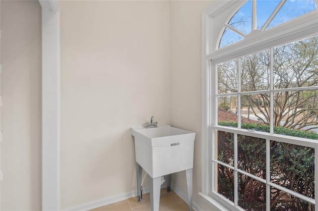 laundry room with light tile patterned floors and a wealth of natural light