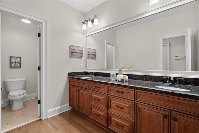 bathroom featuring vanity, hardwood / wood-style flooring, and toilet