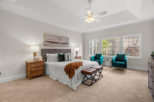 carpeted bedroom featuring crown molding, a tray ceiling, and ceiling fan