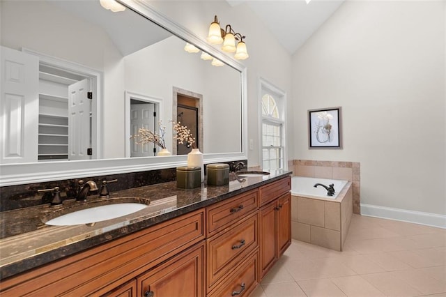 bathroom featuring vanity, tile patterned flooring, vaulted ceiling, and tiled tub