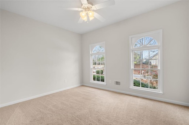 spare room with ceiling fan and carpet