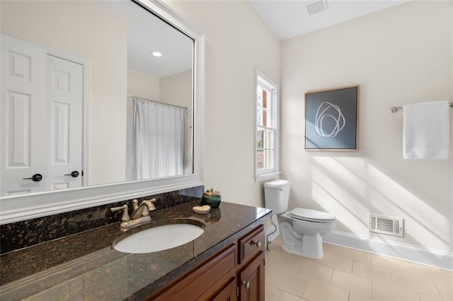 bathroom featuring vanity, toilet, and tile patterned flooring