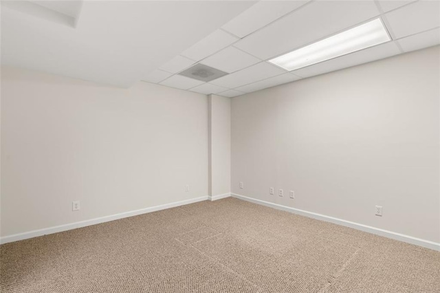 spare room with carpet and a drop ceiling