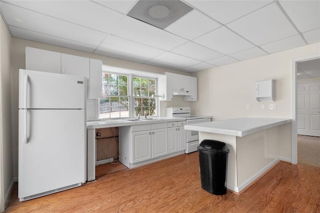 kitchen featuring white cabinetry, white appliances, light hardwood / wood-style flooring, and kitchen peninsula