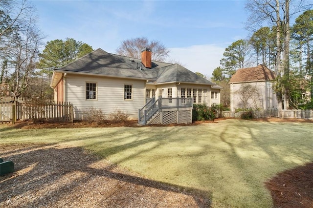 rear view of house featuring a yard and a deck