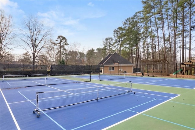 view of tennis court featuring a playground