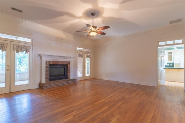 unfurnished living room featuring french doors, crown molding, a ceiling fan, wood finished floors, and baseboards