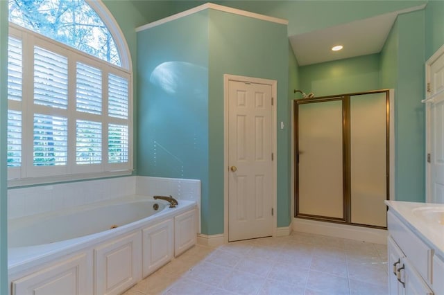 full bath with a bath, a stall shower, vanity, tile patterned floors, and baseboards