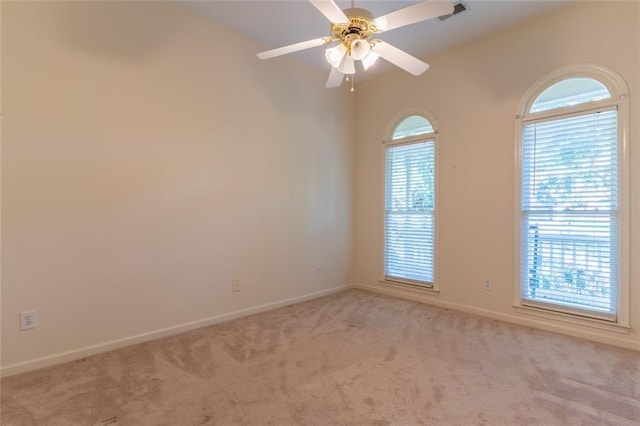 carpeted empty room featuring baseboards and a ceiling fan