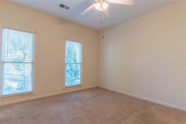 empty room featuring light carpet, baseboards, and ceiling fan
