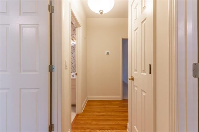 hall featuring light wood-style floors and baseboards