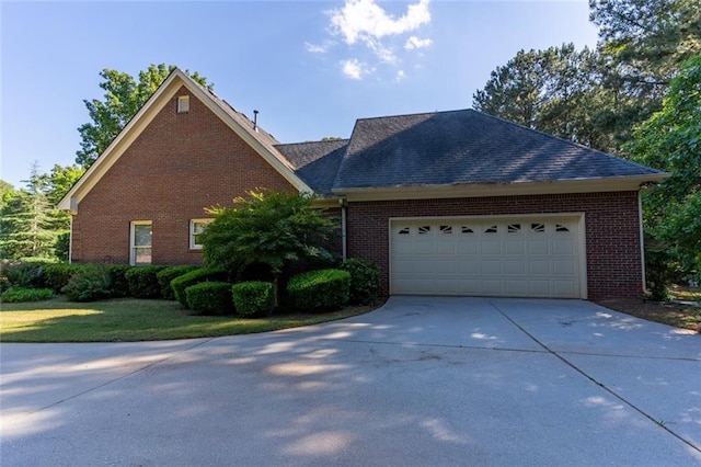 view of front of home featuring concrete driveway, a garage, and brick siding