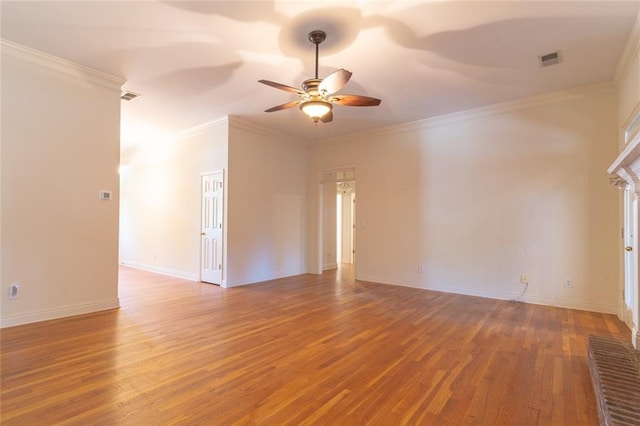 spare room featuring ceiling fan, wood finished floors, crown molding, and baseboards