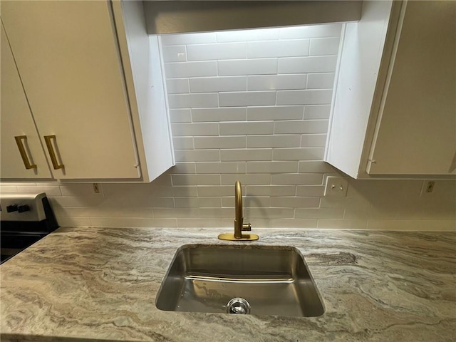 2449 Terrace Trl, Decatur, GA 30035 - kitchen view of a sink, tasteful backsplash, light stone countertops, and white cabinetry