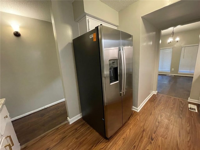 2449 Terrace Trl, Decatur, GA 30035 - kitchen with stainless steel refrigerator with ice dispenser, wood finished floors, a textured ceiling, baseboards, and white cabinets
